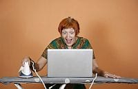 Zaskoczona kobieta w średnim wieku przegląda internet prasując